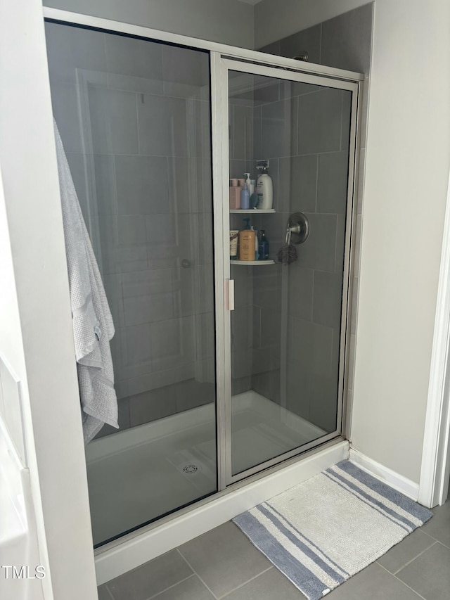 bathroom featuring tile patterned flooring and a shower with shower door