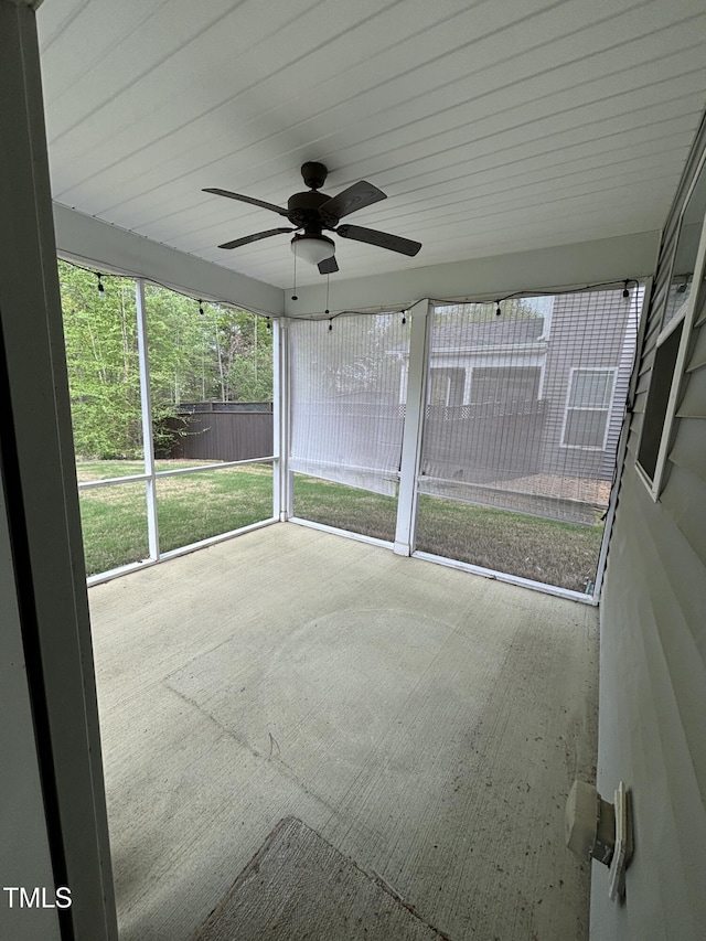 unfurnished sunroom featuring ceiling fan and plenty of natural light
