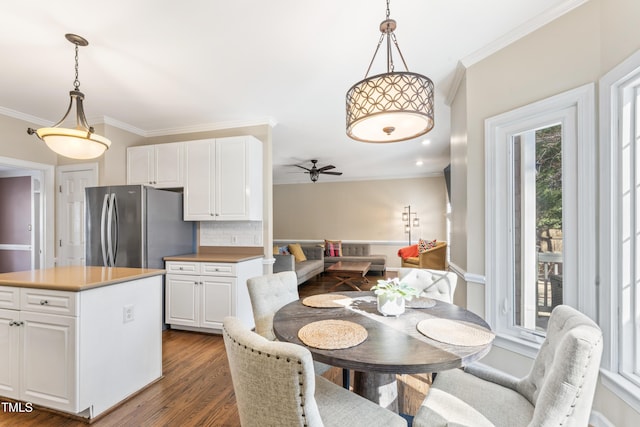 dining room featuring a ceiling fan, crown molding, and dark wood-type flooring