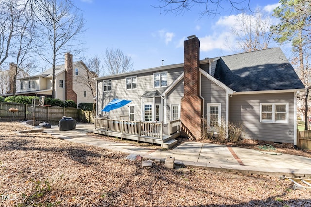 back of property with fence, a chimney, crawl space, a deck, and a patio area