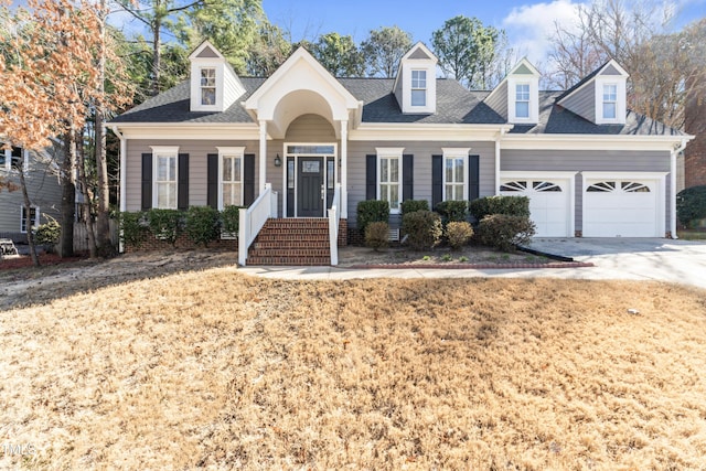 cape cod-style house with an attached garage, driveway, and a shingled roof