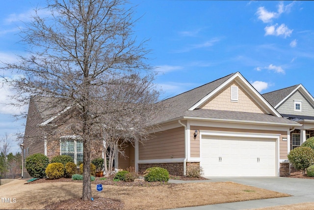 view of front of property featuring a shingled roof, stone siding, driveway, and an attached garage