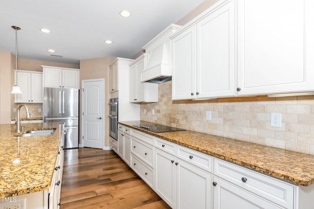 kitchen featuring appliances with stainless steel finishes, light stone counters, wood finished floors, decorative light fixtures, and white cabinetry