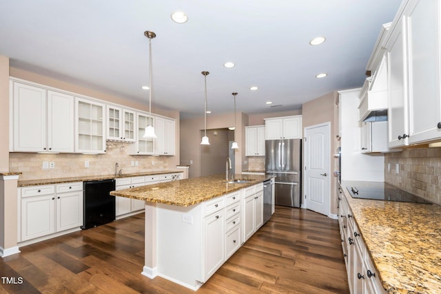 kitchen with light stone counters, a sink, black appliances, dark wood finished floors, and glass insert cabinets