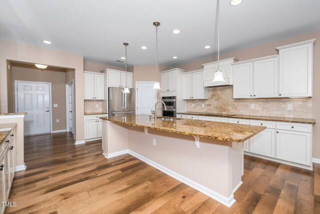 kitchen featuring stainless steel appliances, white cabinetry, and dark wood-style floors