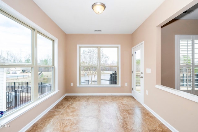 interior space featuring a wealth of natural light, visible vents, and baseboards