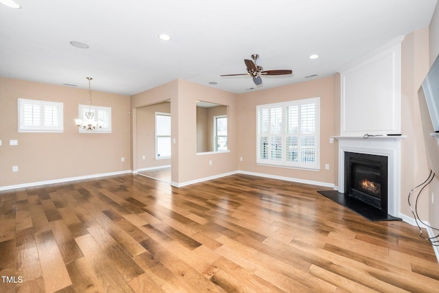 unfurnished living room with a healthy amount of sunlight, light wood-style flooring, and a glass covered fireplace