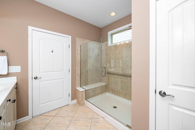 bathroom with baseboards, a stall shower, vanity, and tile patterned floors