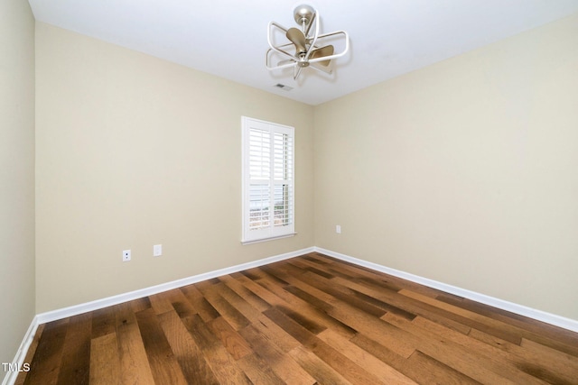 spare room with visible vents, dark wood finished floors, and baseboards