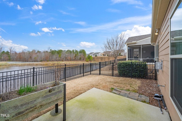 view of patio with a water view, a sunroom, and a fenced backyard