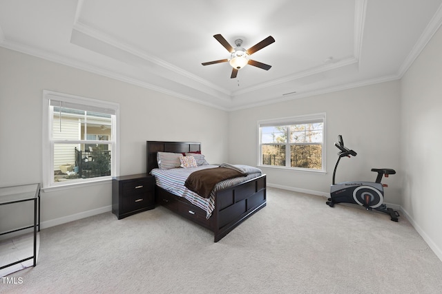 bedroom with crown molding, ceiling fan, a tray ceiling, and light carpet