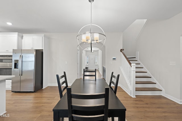 dining area with a notable chandelier and light wood-type flooring