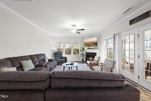 living room featuring ornamental molding, wood-type flooring, and ceiling fan