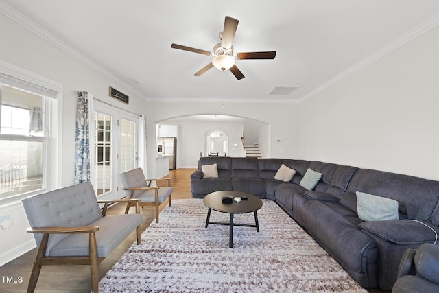 living room featuring ornamental molding, hardwood / wood-style floors, ceiling fan, and french doors