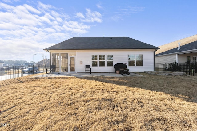 back of property with a yard and a patio area