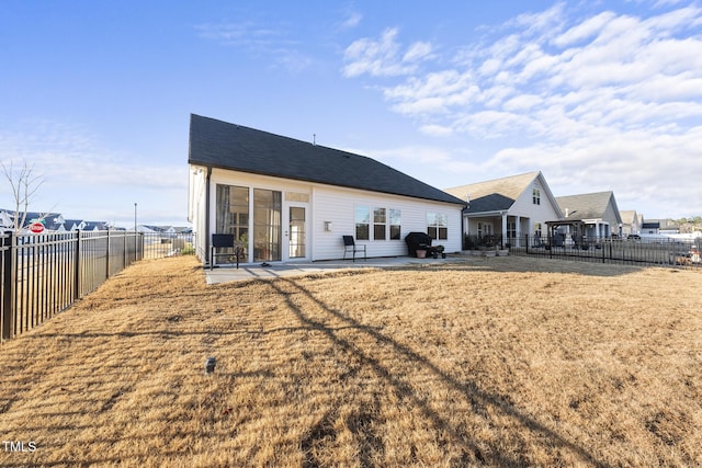 rear view of house featuring a patio and a lawn