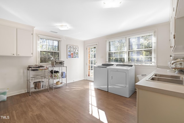 laundry room with hardwood / wood-style floors, ornamental molding, sink, and washer and dryer