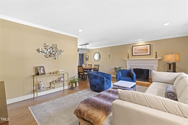 living room featuring ornamental molding, a tile fireplace, and light wood-type flooring