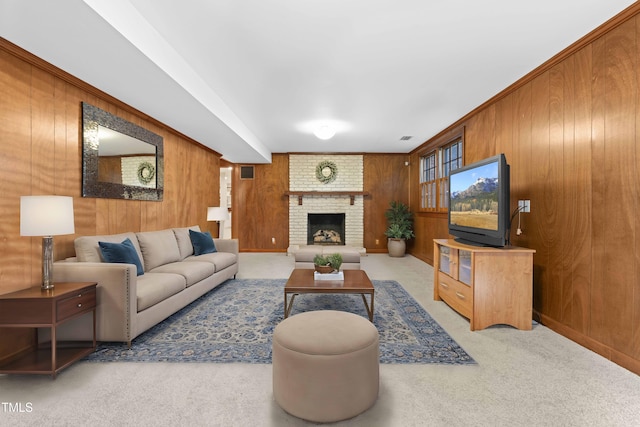 living room with wooden walls, carpet floors, and a brick fireplace