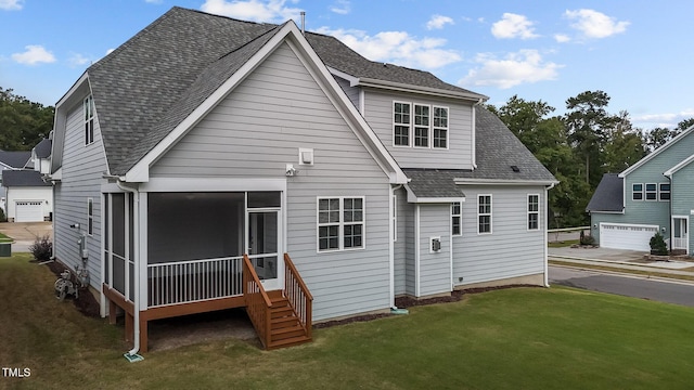 back of house with a garage, a sunroom, and a yard