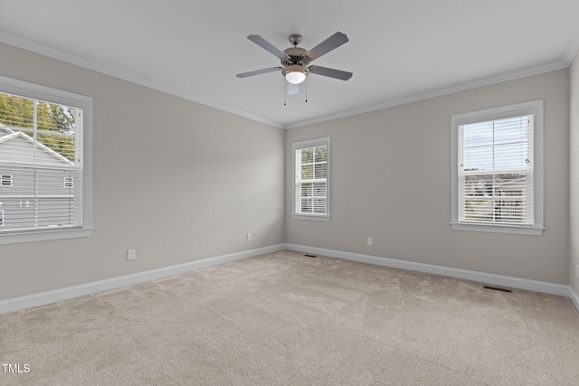 carpeted empty room with crown molding, ceiling fan, and a wealth of natural light