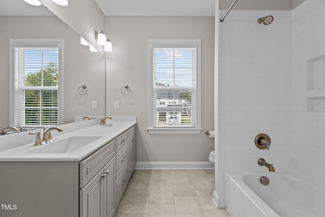 full bathroom featuring vanity, toilet, tiled shower / bath combo, and tile patterned flooring