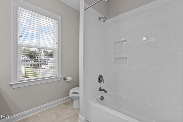 bathroom with tiled shower / bath combo, tile patterned floors, and toilet