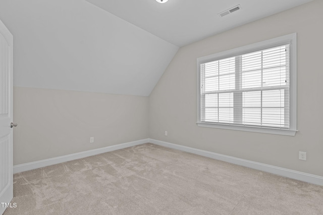 additional living space with light colored carpet and lofted ceiling