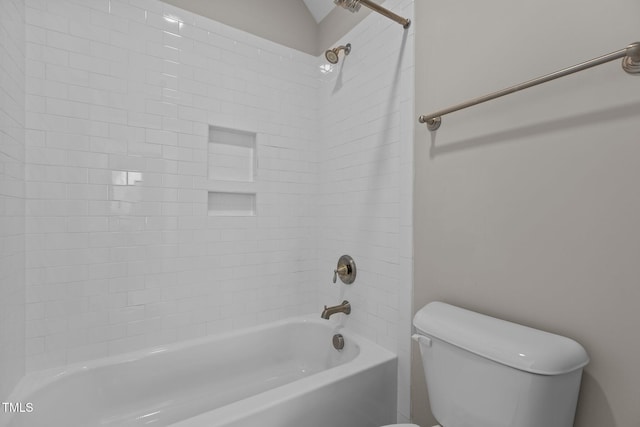 bathroom with tiled shower / bath combo and toilet