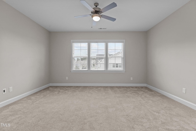 spare room with light colored carpet and ceiling fan