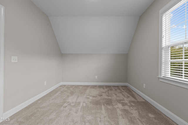 additional living space with lofted ceiling and light carpet