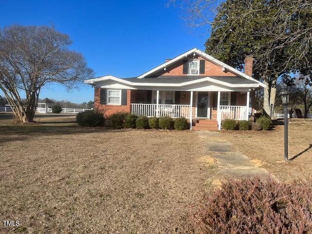 view of front of property with covered porch and a front lawn