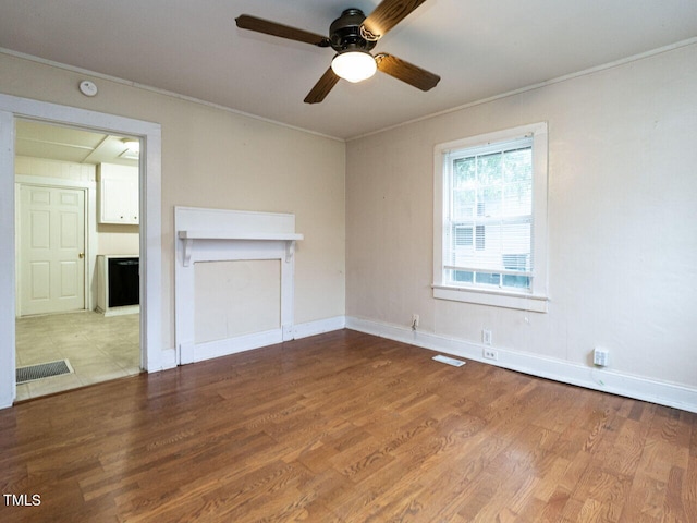 unfurnished living room with ceiling fan, ornamental molding, and light hardwood / wood-style flooring