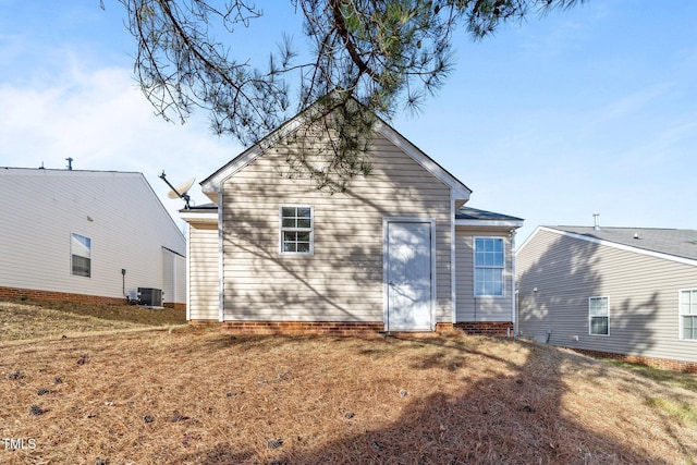 back of property featuring a yard and central AC