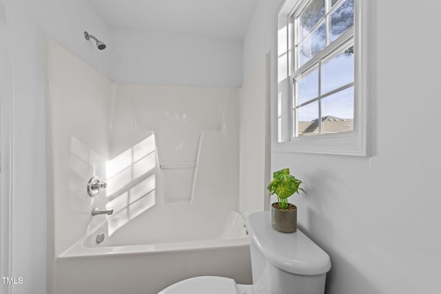 bathroom featuring bathtub / shower combination and toilet