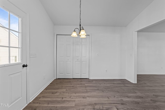 unfurnished dining area with an inviting chandelier and dark hardwood / wood-style floors