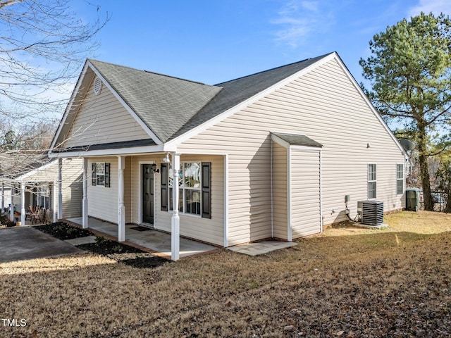 view of home's exterior with a yard, central AC unit, and a patio area