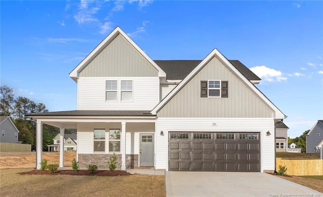 531 Southerland Peak, Raeford, NC 28376 - view of front of home with stone siding, concrete driveway, covered porch, fence, and board and batten siding