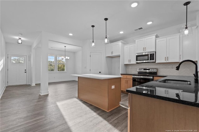 531 Southerland Peak, Raeford, NC 28376 - kitchen with a sink, decorative backsplash, stainless steel appliances, dark wood finished floors, and visible vents
