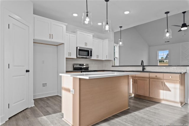 531 Southerland Peak, Raeford, NC 28376 - kitchen featuring a center island, a sink, decorative backsplash, light wood-style floors, and stainless steel appliances