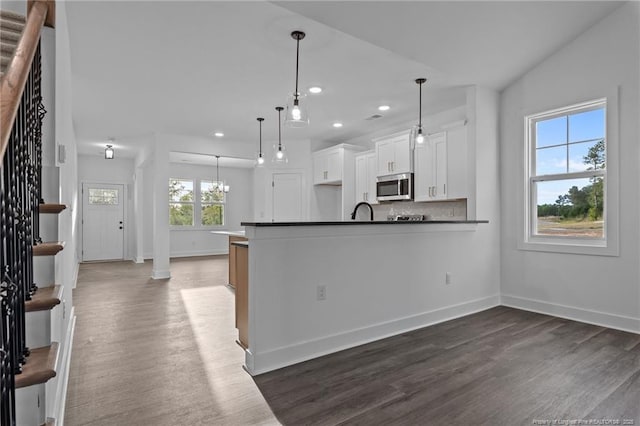 531 Southerland Peak, Raeford, NC 28376 - kitchen with stainless steel microwave, dark countertops, dark wood-style floors, and recessed lighting
