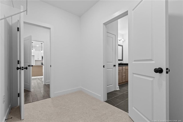 531 Southerland Peak, Raeford, NC 28376 - hallway featuring dark colored carpet, baseboards, and a sink