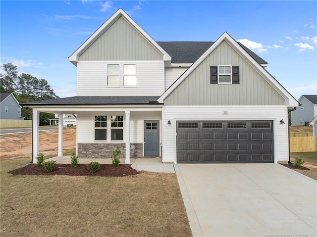 531 Southerland Peak, Raeford, NC 28376 - view of front of house with a front lawn, a porch, stone siding, concrete driveway, and board and batten siding