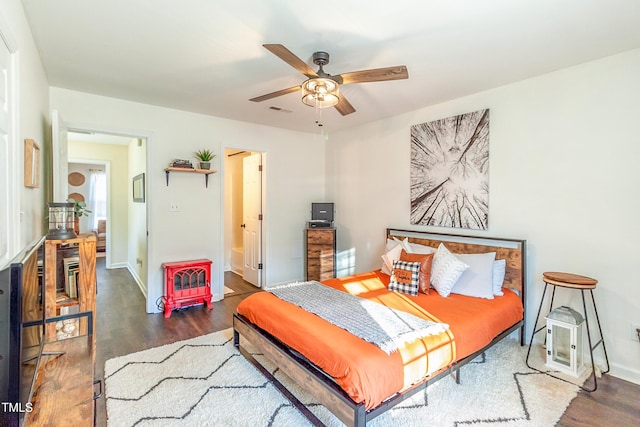 bedroom featuring ceiling fan, dark hardwood / wood-style flooring, and ensuite bath