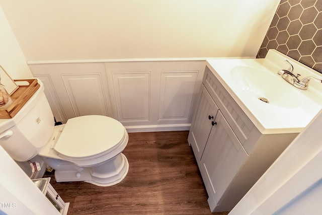 bathroom with hardwood / wood-style flooring, vanity, and toilet