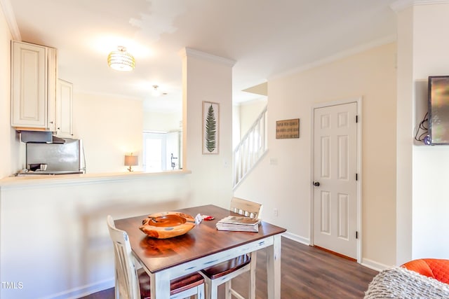 dining area with crown molding and dark hardwood / wood-style flooring