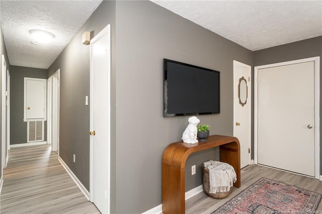 foyer featuring a textured ceiling and light hardwood / wood-style flooring