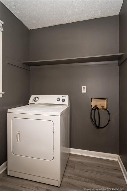 clothes washing area with dark hardwood / wood-style flooring, washer / dryer, and a textured ceiling