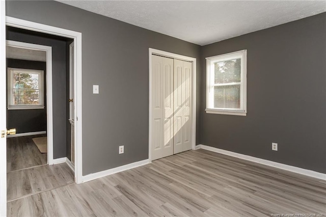 unfurnished bedroom with light hardwood / wood-style floors and a closet