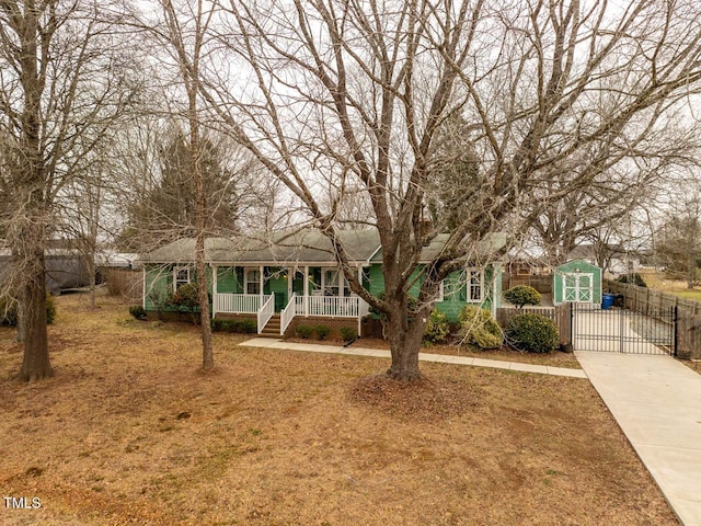 ranch-style home featuring a porch and a storage shed